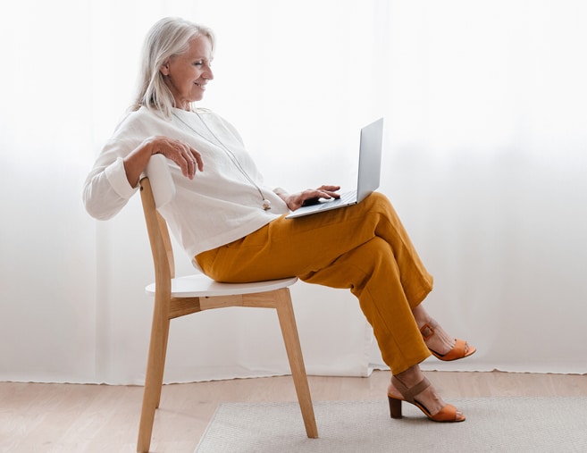 Woman sitting in a chair with computer on her lap